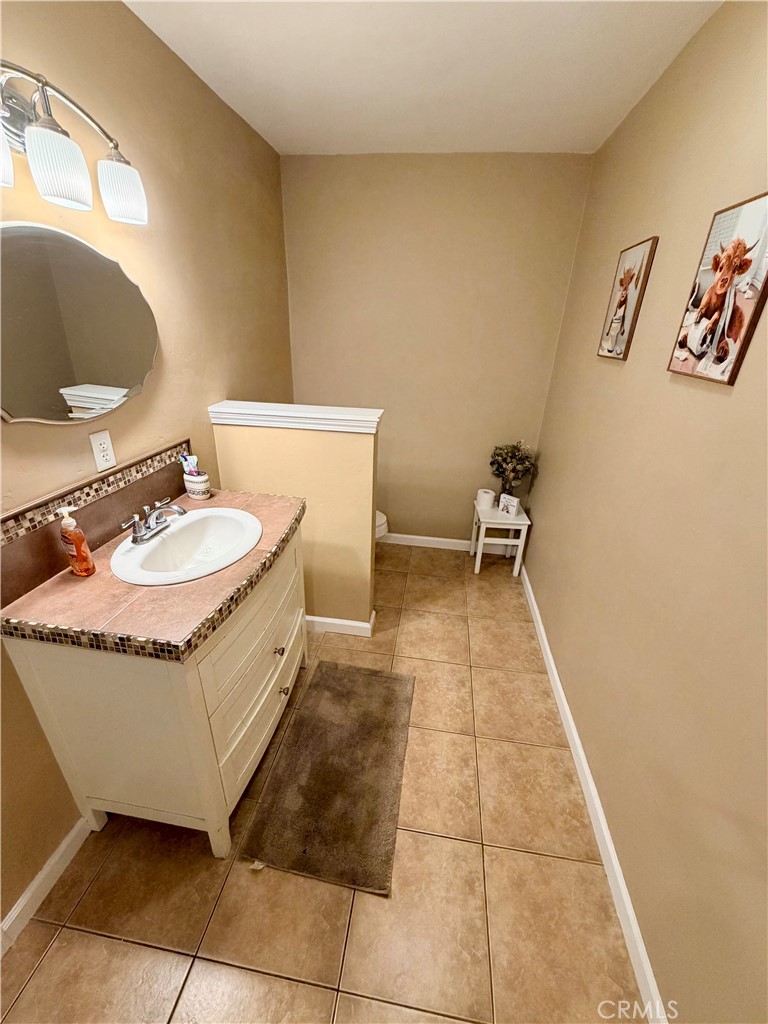 1896 Maryvale Lane Hemet, CA 92544 - Photo 15 of 33 a bathroom with a granite countertop sink a toilet and a mirror