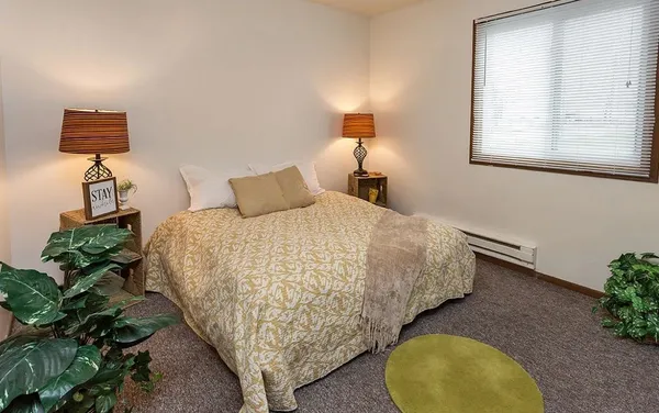 a bedroom with a bed and a potted plant