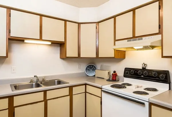 a kitchen with stainless steel appliances a sink a stove and a window