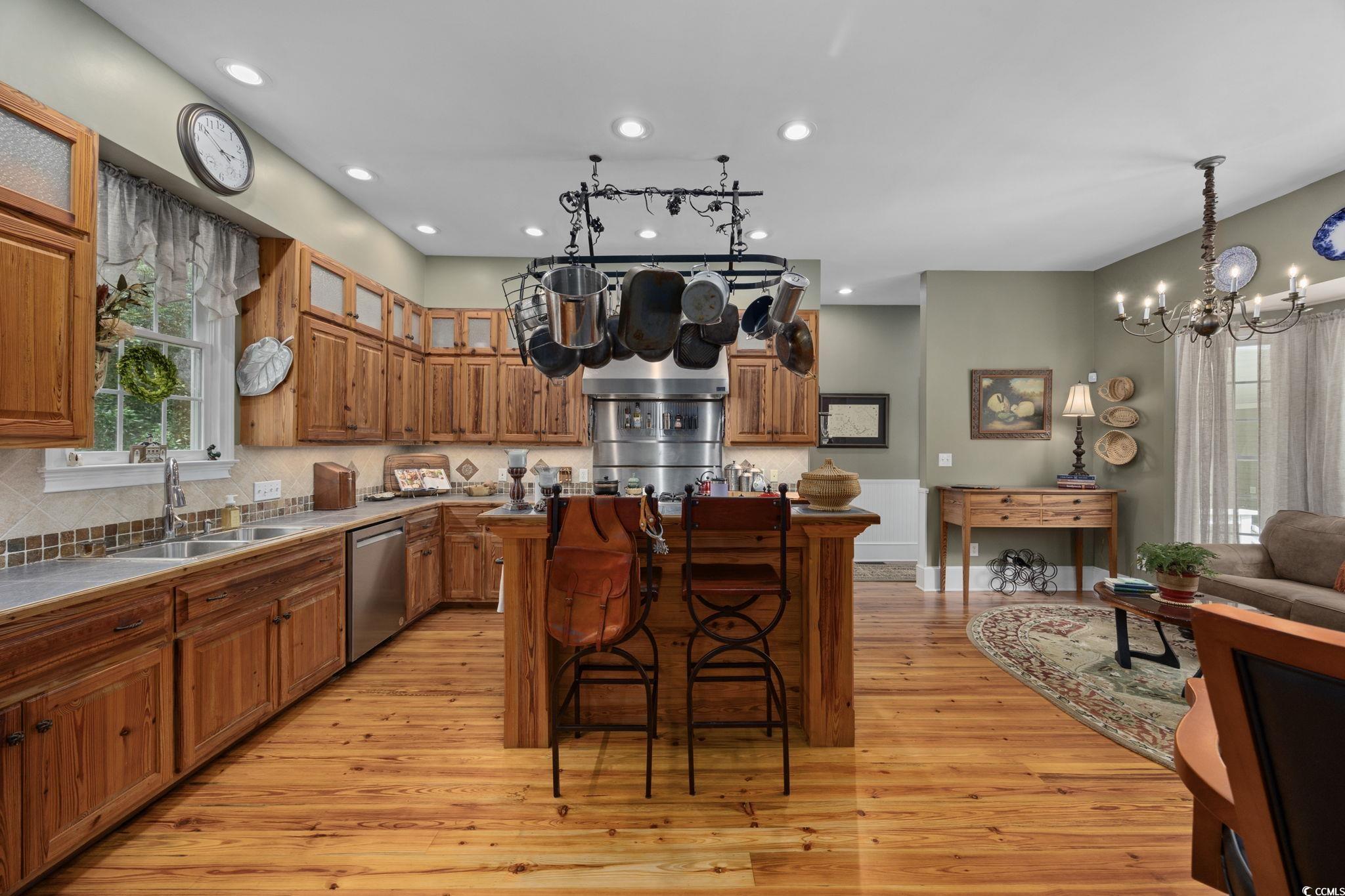 3750 Highway 813 Conway Sc 29526 Conway, SC 29526 - Photo 11 of 40 Kitchen featuring a breakfast bar, brown cabinetry, decorative backsplash, a kitchen island, and light wood-style flooring