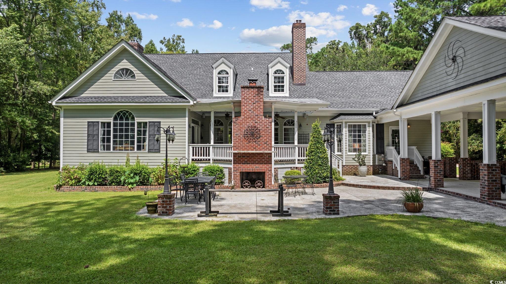 3750 Highway 813 Conway Sc 29526 Conway, SC 29526 - Photo 3 of 40 Rear view of house with a yard, a shingled roof, covered porch, and a chimney