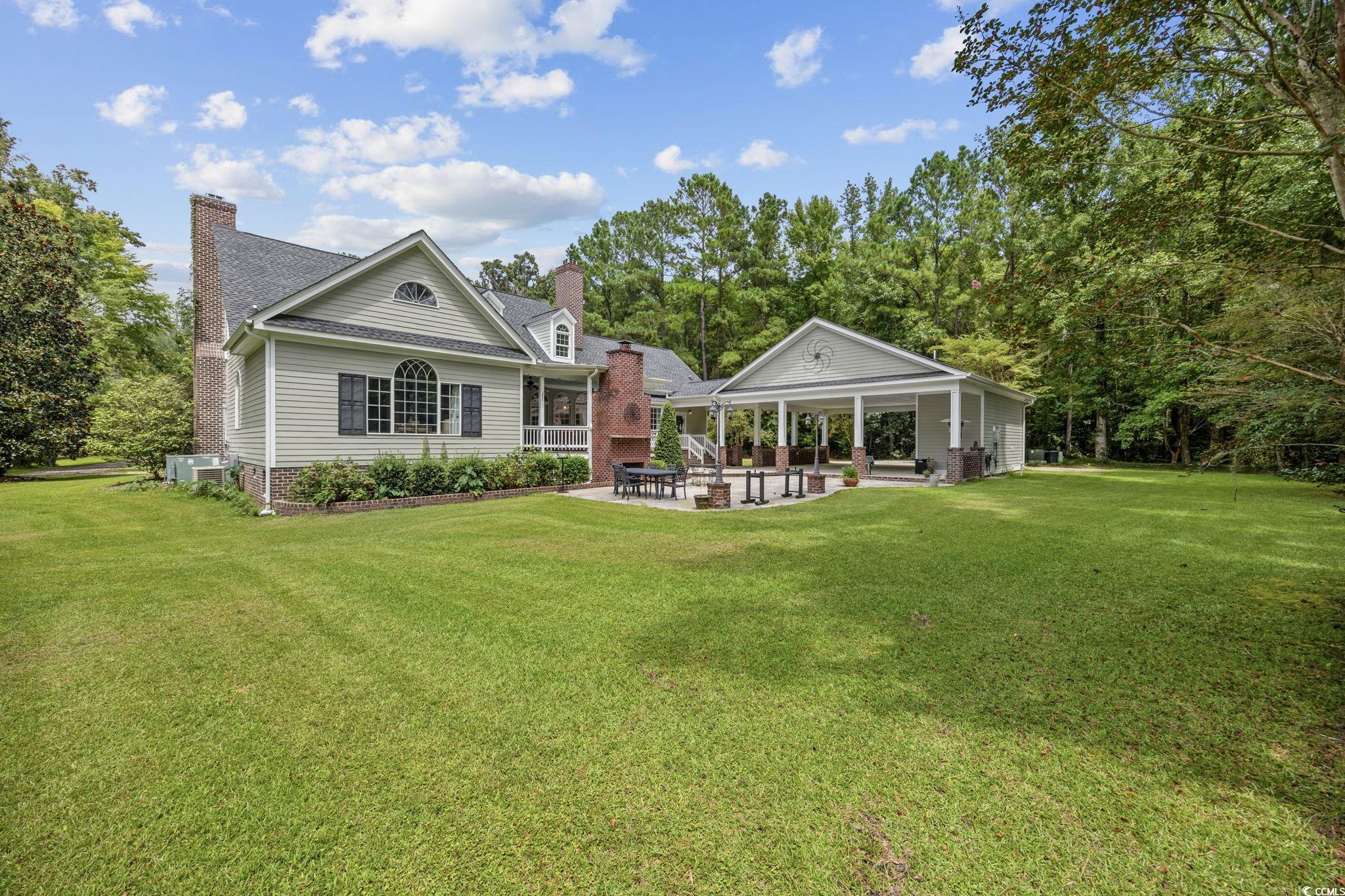 3750 Highway 813 Conway Sc 29526 Conway, SC 29526 - Photo 32 of 40 Rear view of property featuring a patio, a chimney, and a lawn