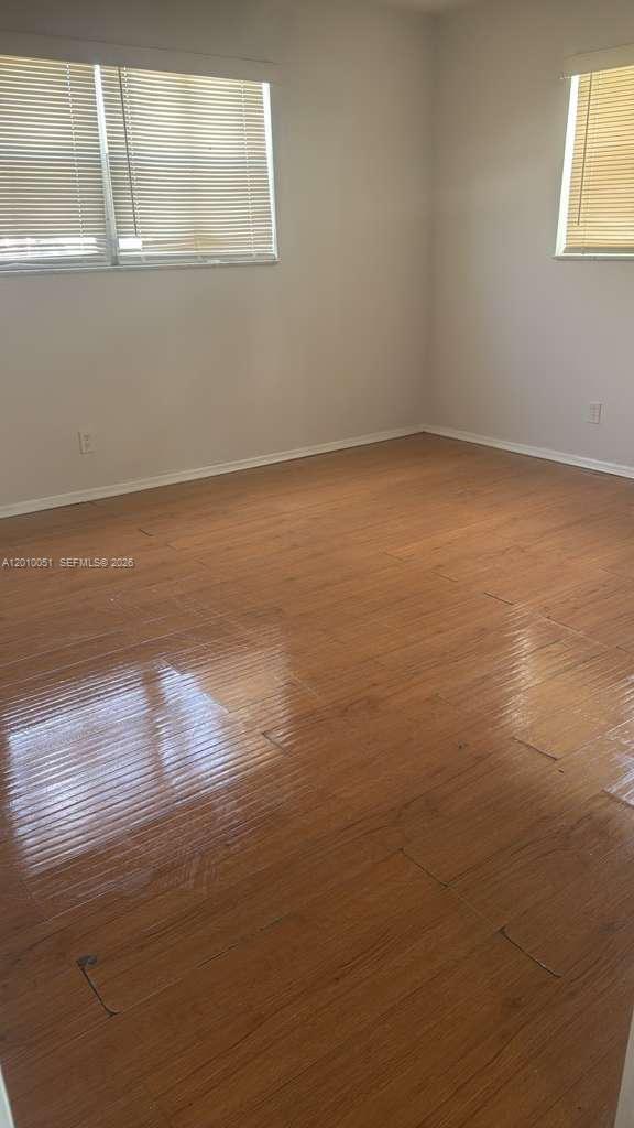 7910 North Colony Circle, Unit 101 Tamarac, FL 33321 - Photo 15 of 17 a view of an empty room with wooden floor and a window