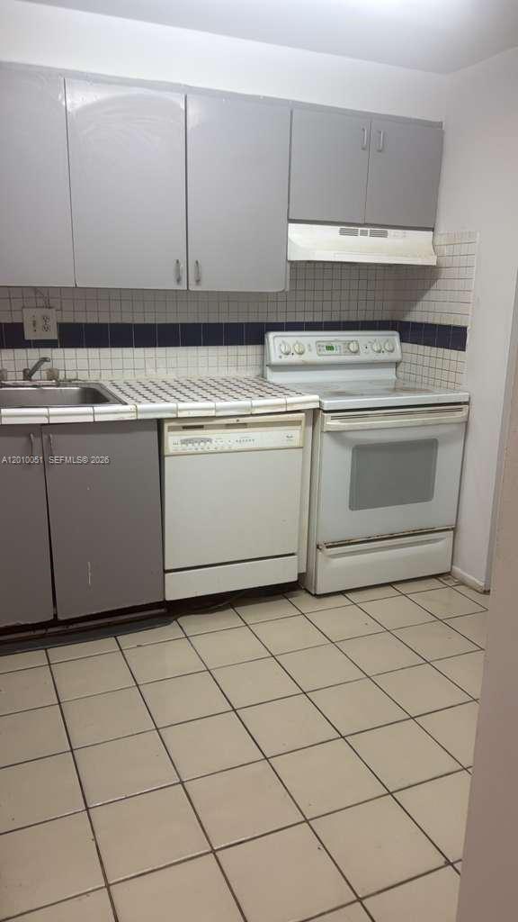 7910 North Colony Circle, Unit 101 Tamarac, FL 33321 - Photo 4 of 17 a stove top oven sitting inside of a kitchen