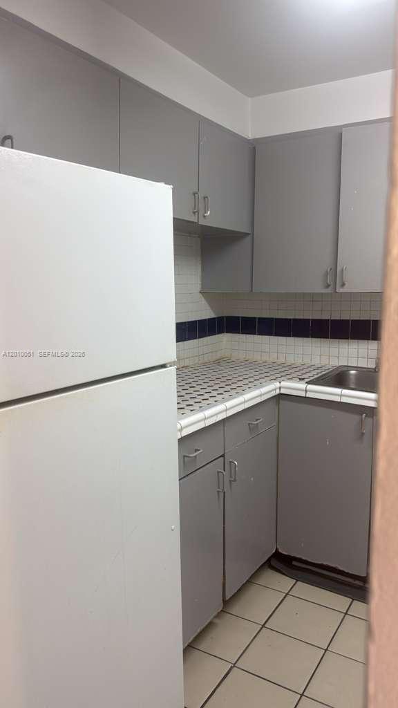 7910 North Colony Circle, Unit 101 Tamarac, FL 33321 - Photo 5 of 17 a kitchen with cabinets and white stainless steel appliances