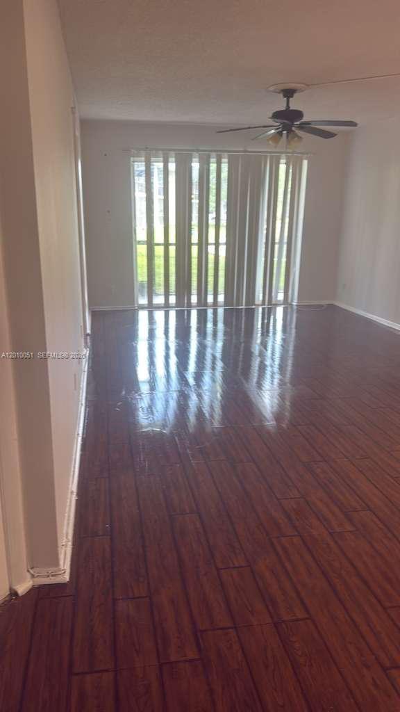 7910 North Colony Circle, Unit 101 Tamarac, FL 33321 - Photo 8 of 17 wooden floor in an empty room with a window