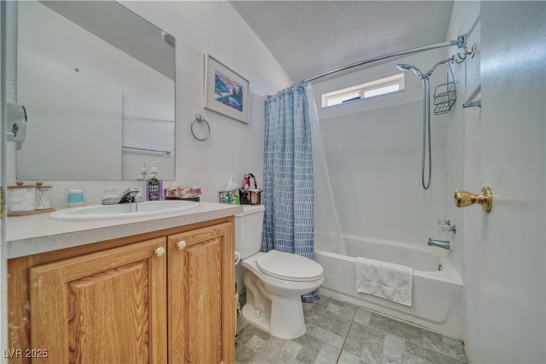 2891 Rio Rico Drive Pahrump, NV 89048 - Photo 19 of 45 Full bathroom featuring toilet, shower / tub combo with curtain, and vanity.