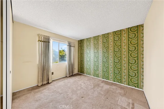 a view of an empty room with a window and bathroom