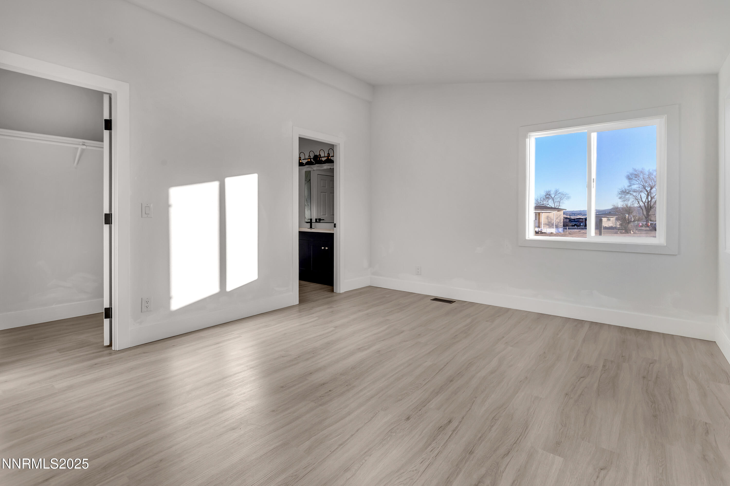 320 Ramsey Way Reno, NV 89506 - Photo 17 of 40 a view of an empty room with wooden floor and a window