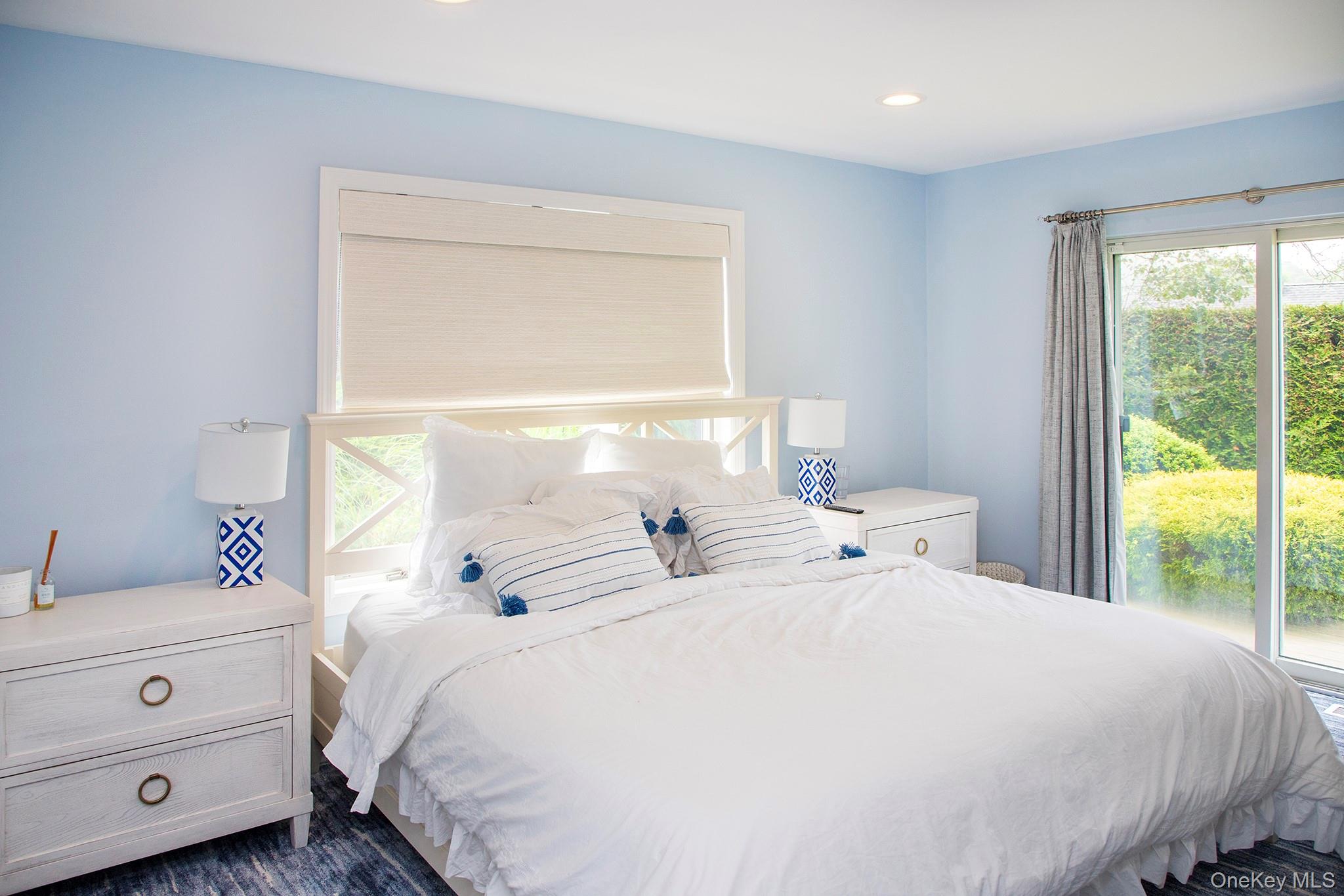 16 Laila Lane Remsenburg, NY 11960 - Photo 15 of 36 a large white bed sitting in a bedroom next to a window