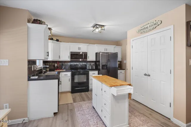 a kitchen with a refrigerator a stove top oven and cabinets