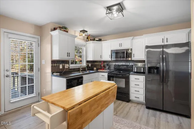 a kitchen with granite countertop a refrigerator stove top oven and sink