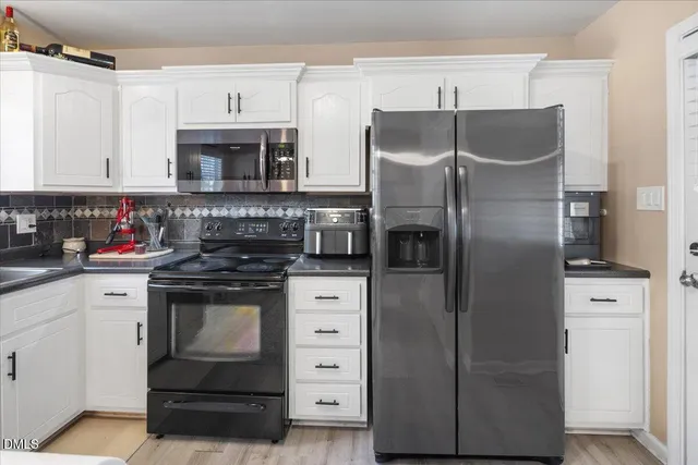 a kitchen with stainless steel appliances kitchen island granite countertop a refrigerator and a stove