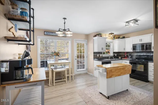 a kitchen with stainless steel appliances a stove top oven a sink and a refrigerator