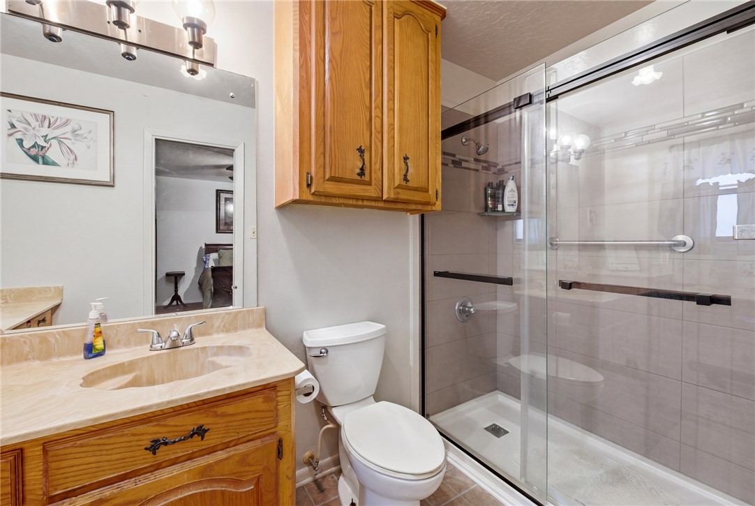 706 Mesquite Street Calvert, TX 77837 - Photo 16 of 23 a bathroom with a granite countertop sink toilet and shower