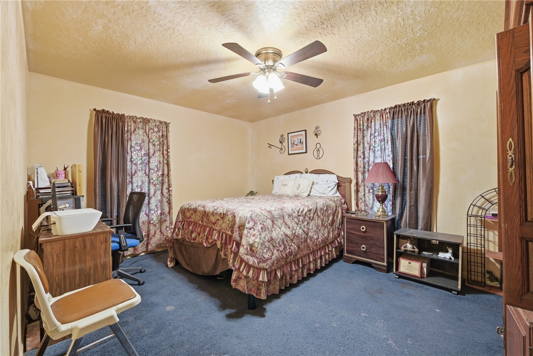 706 Mesquite Street Calvert, TX 77837 - Photo 20 of 23 a bedroom with a bed and a chandelier