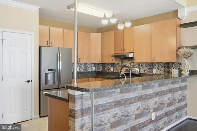 a kitchen with stainless steel appliances granite countertop a sink a stove and a refrigerator