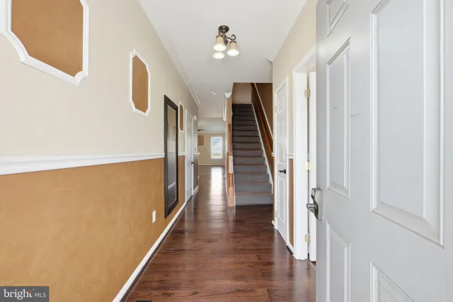 a view of a hallway with wooden floor and staircase