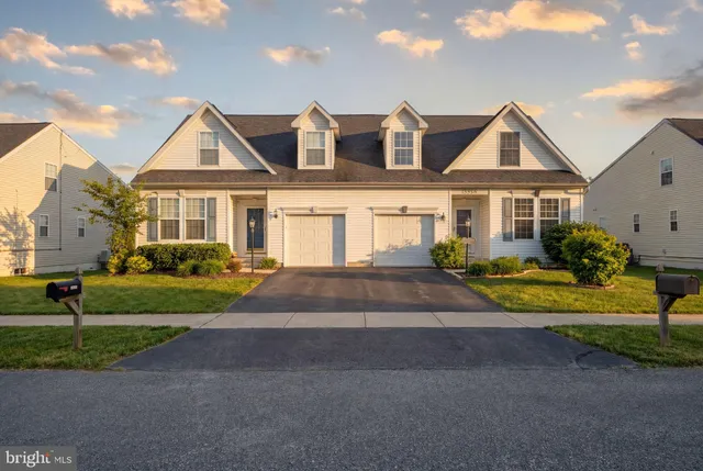a front view of a house with a yard and trees