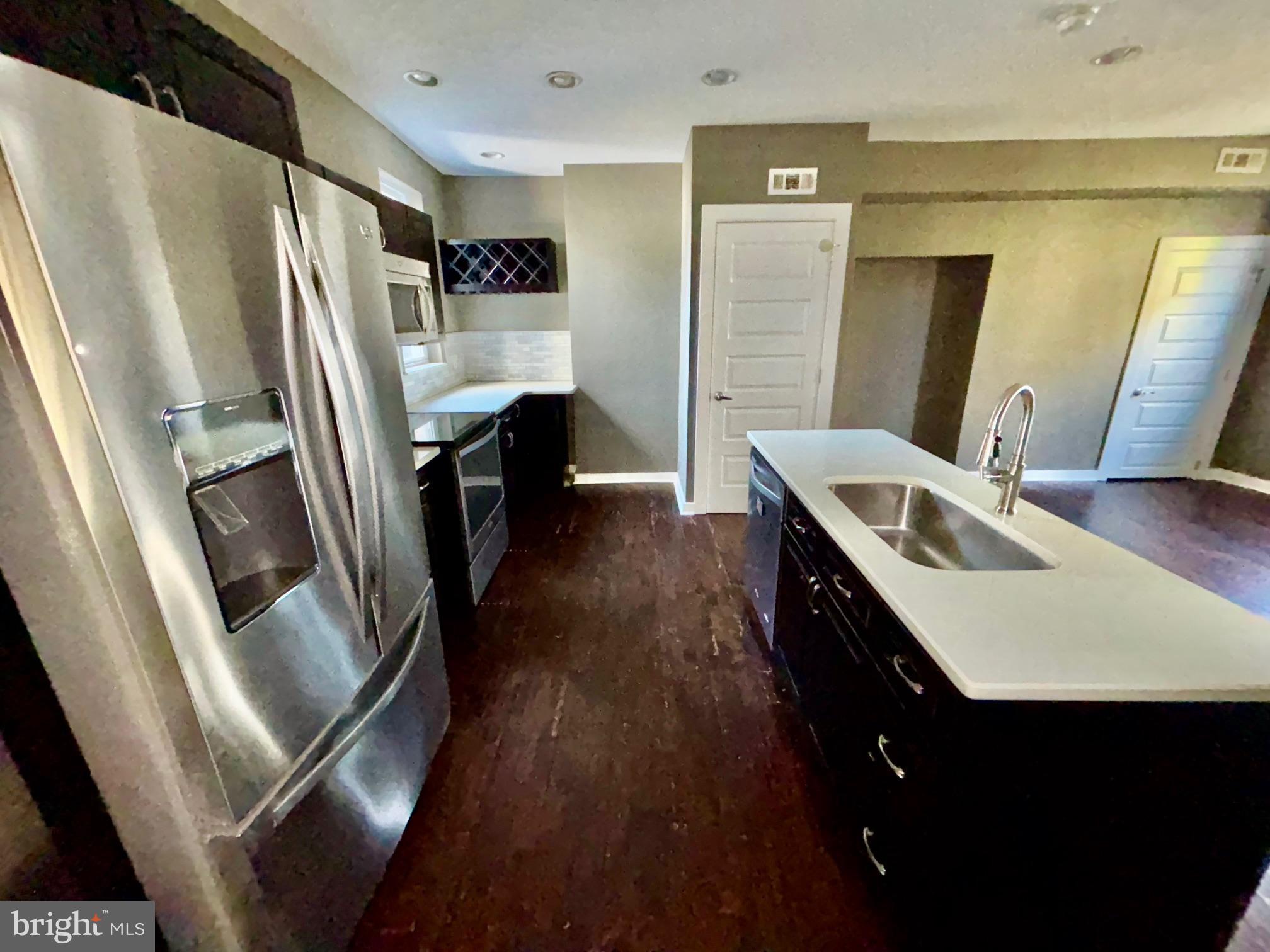 1865 Frankford Avenue, Unit B Philadelphia, PA 19125 - Photo 4 of 12 a kitchen with kitchen island a counter top space a sink a refrigerator and a stove