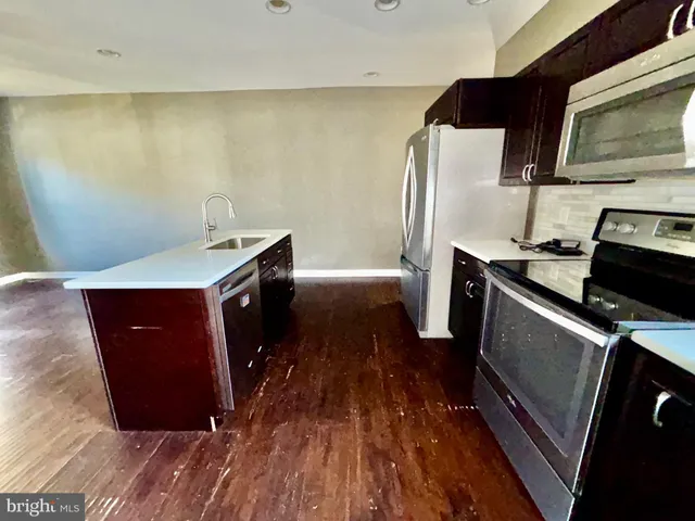 a kitchen with stainless steel appliances a microwave a stove and a refrigerator