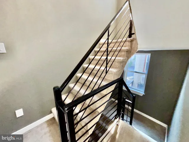a view of a hallway with wooden floor and stairs