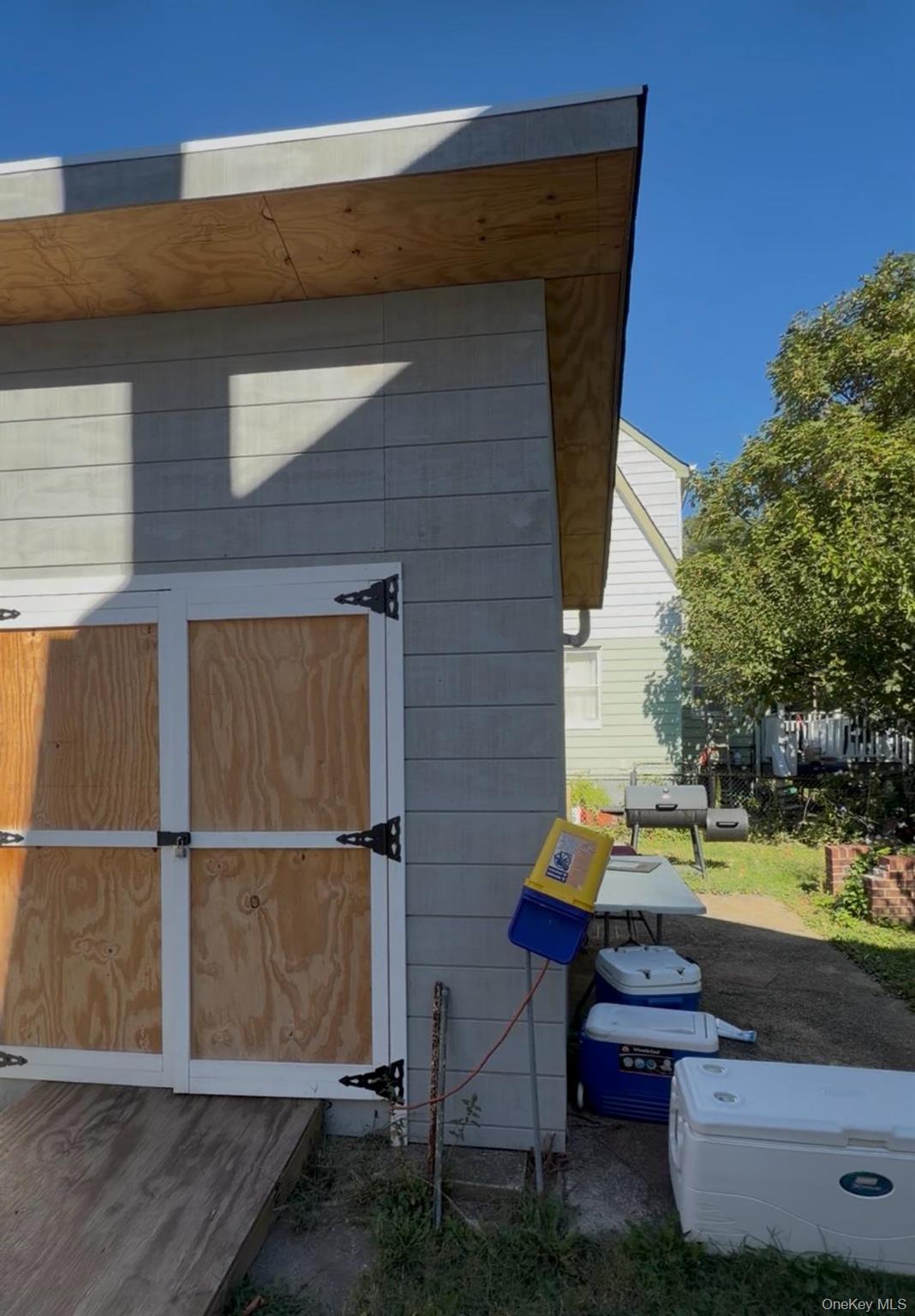 197-05 116th Avenue Queens, NY 11412 - Photo 2 of 2 a backyard of a house with wooden floor and outdoor seating