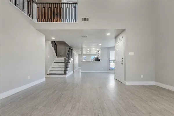 a view of a hallway with wooden floor and stairs