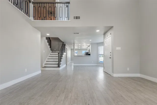 a view of a hallway with wooden floor and stairs