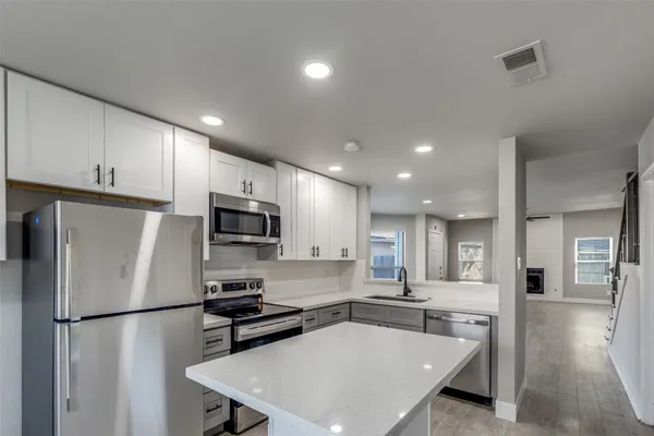 a kitchen with stainless steel appliances a refrigerator stove microwave and cabinets