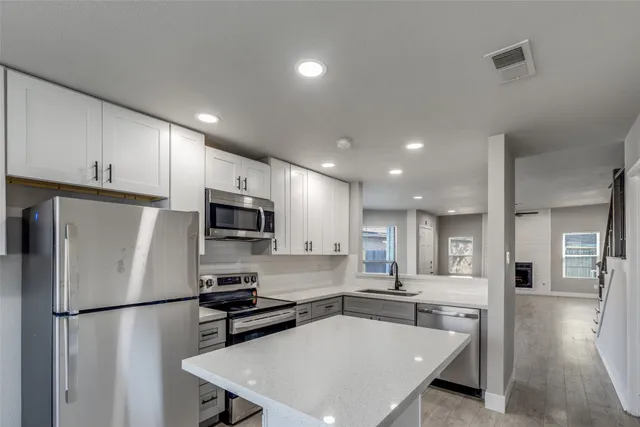 a kitchen with stainless steel appliances a refrigerator stove microwave and cabinets