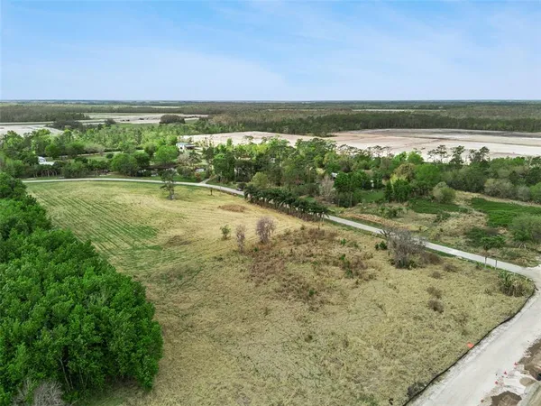 a view of a lake in middle of a field