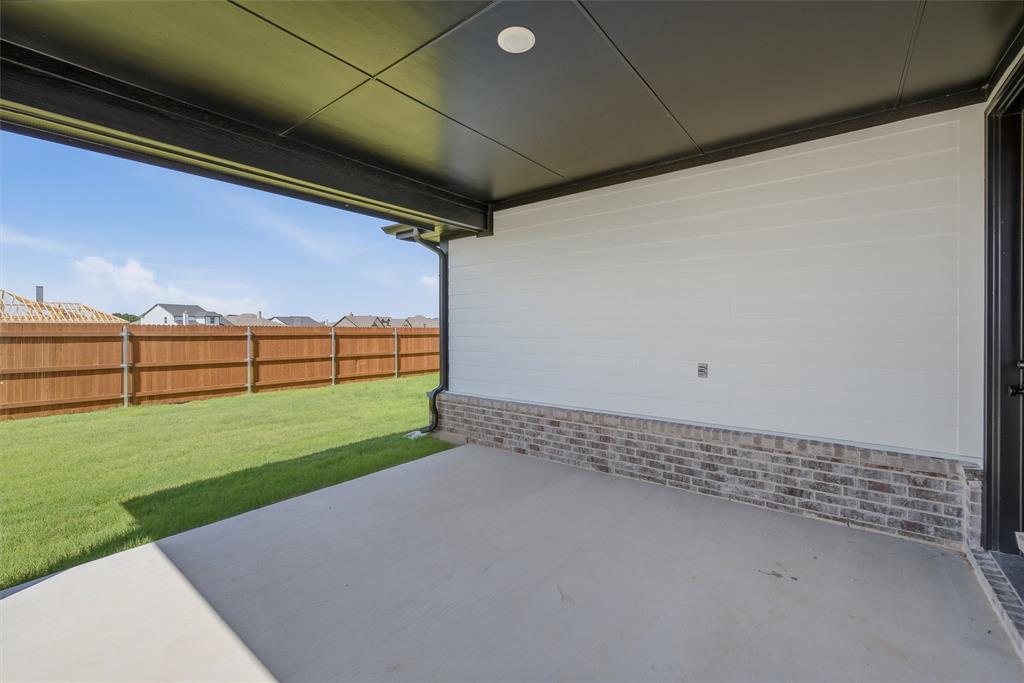 1213 Colca Drive Springtown, TX 76082 - Photo 19 of 23 Covered concrete patio with a dark soffit ceiling and white siding