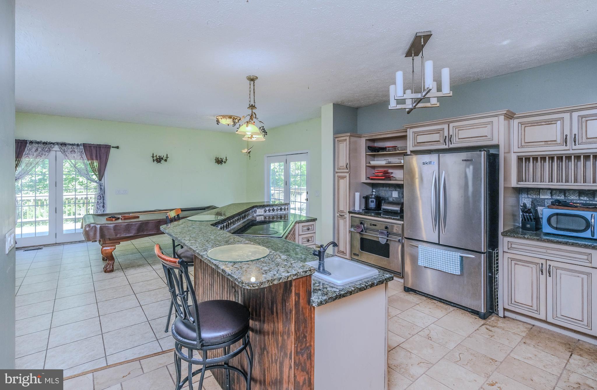 1195 Shangri-La Road Bentonville, VA 22610 - Photo 41 of 64 a kitchen with granite countertop a table chairs stainless steel appliances and cabinets