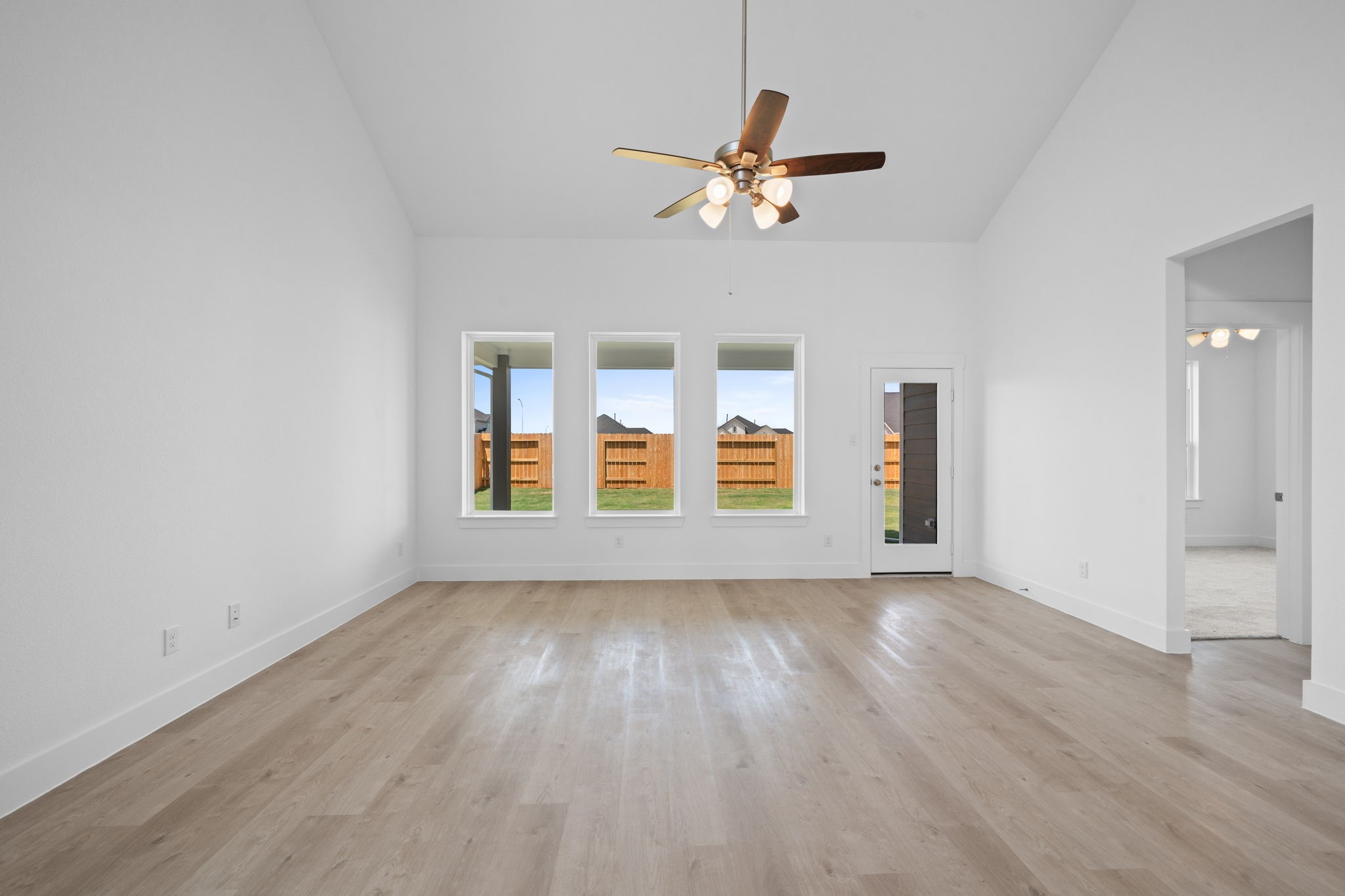 309 Gambels Quail Road Hempstead, TX 77445 - Photo 9 of 27 an empty room with wooden floor chandelier fan and windows