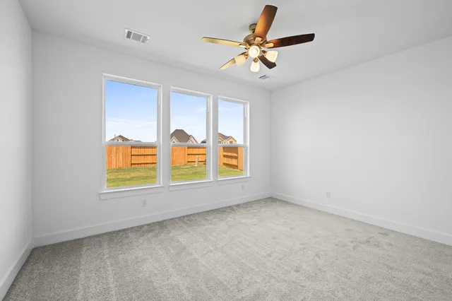 an empty room with window and ceiling fan