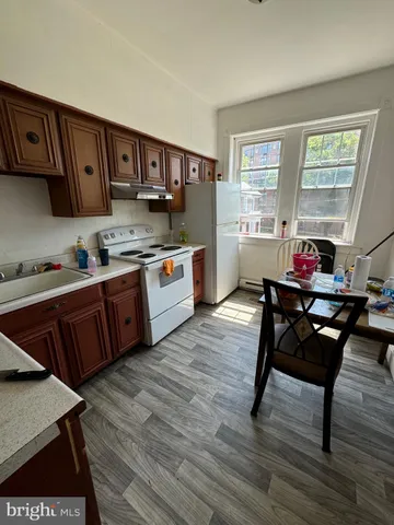 a kitchen with a table chairs stove and wooden cabinets