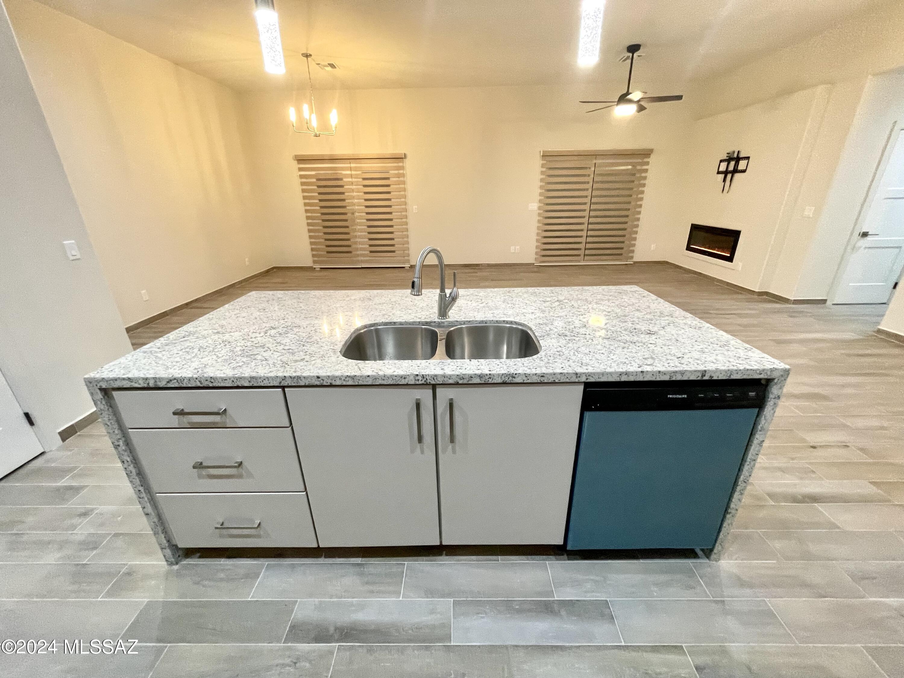 1049 Camino Estrella Rio Rico, AZ 85648 - Photo 9 of 28 a kitchen with granite countertop a sink and a window