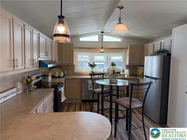 a kitchen with sink a refrigerator and chairs
