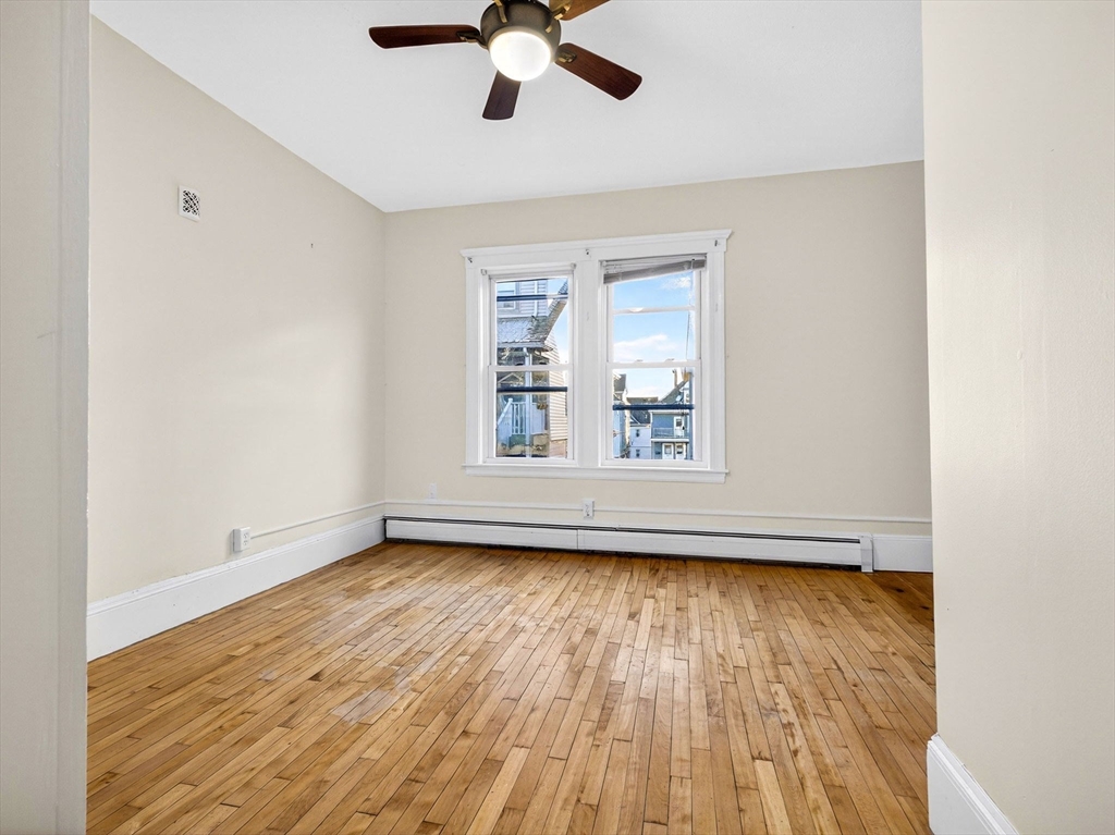 12 Braemore Road, Unit 2 Medford, MA 02155 - Photo 13 of 24 an empty room with wooden floor chandelier fan and windows