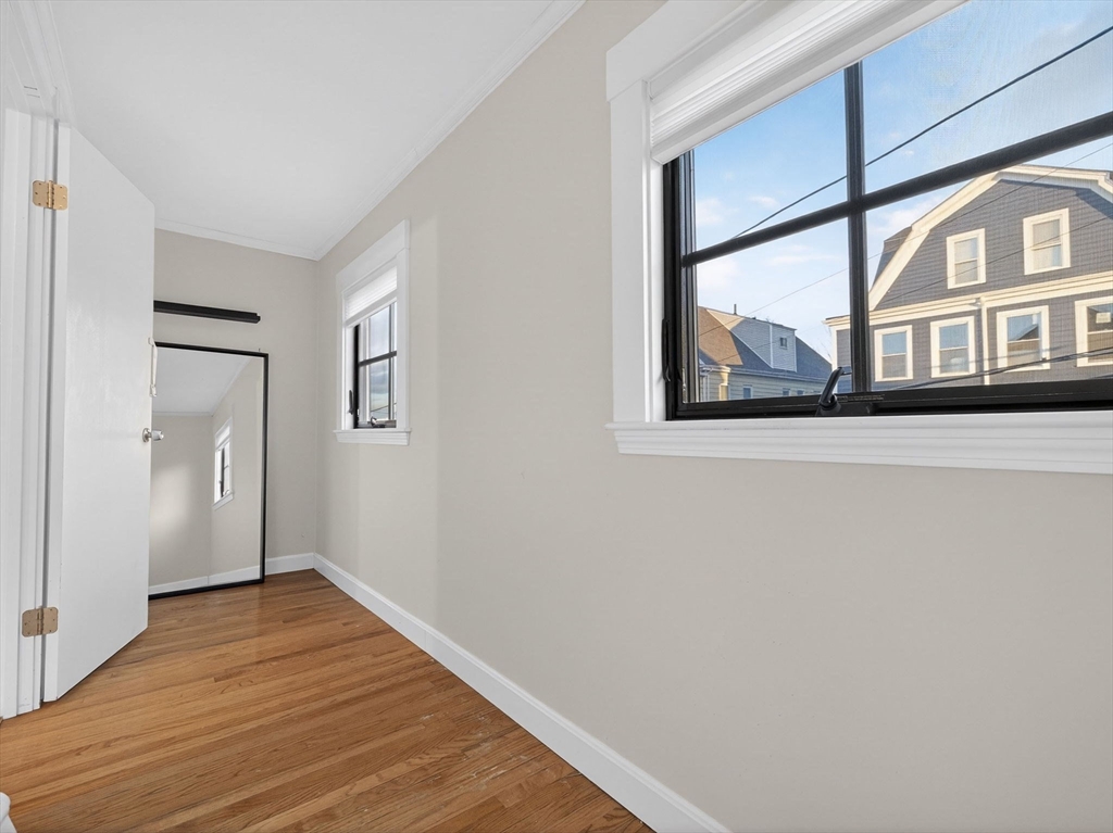12 Braemore Road, Unit 2 Medford, MA 02155 - Photo 16 of 24 a view of an empty room with wooden floor and a window