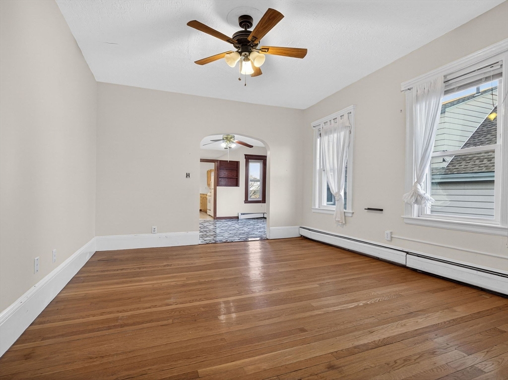 12 Braemore Road, Unit 2 Medford, MA 02155 - Photo 17 of 24 an empty room with wooden floor and windows