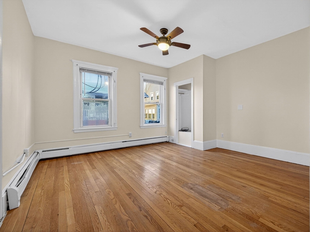 12 Braemore Road, Unit 2 Medford, MA 02155 - Photo 18 of 24 a view of an empty room with wooden floor and a window