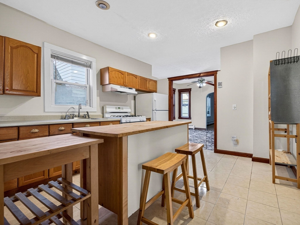 12 Braemore Road, Unit 2 Medford, MA 02155 - Photo 2 of 24 a kitchen with stainless steel appliances granite countertop a stove a sink and a refrigerator