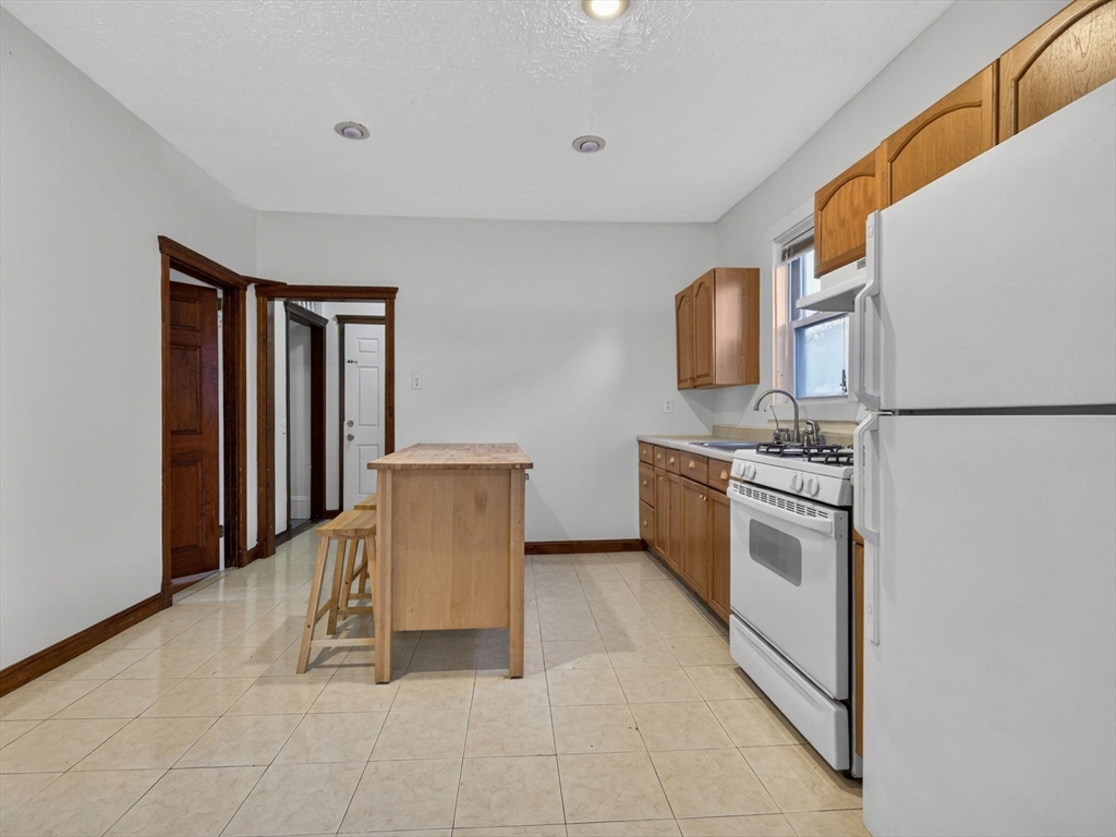 12 Braemore Road, Unit 2 Medford, MA 02155 - Photo 3 of 24 a kitchen with stainless steel appliances granite countertop a stove a sink and a refrigerator