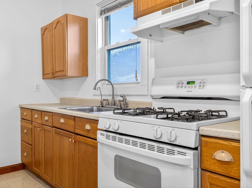 12 Braemore Road, Unit 2 Medford, MA 02155 - Photo 7 of 24 a kitchen with stainless steel appliances granite countertop a sink stove and cabinets