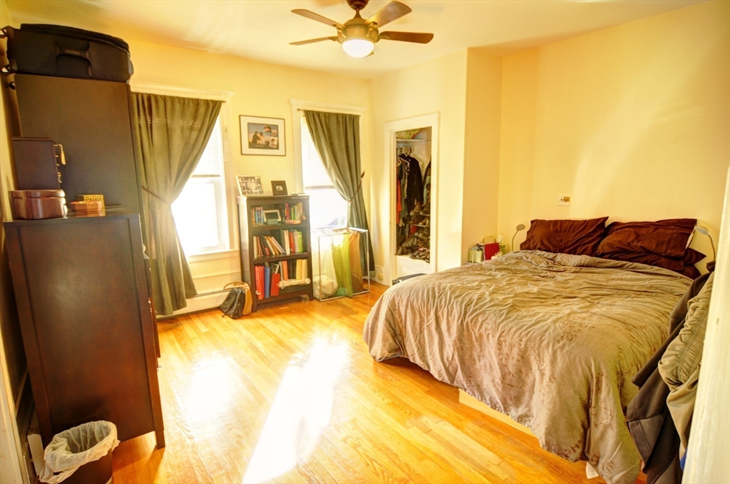 12 Braemore Road, Unit 2 Medford, MA 02155 - Photo 8 of 19 a bedroom with a bed and wooden floor