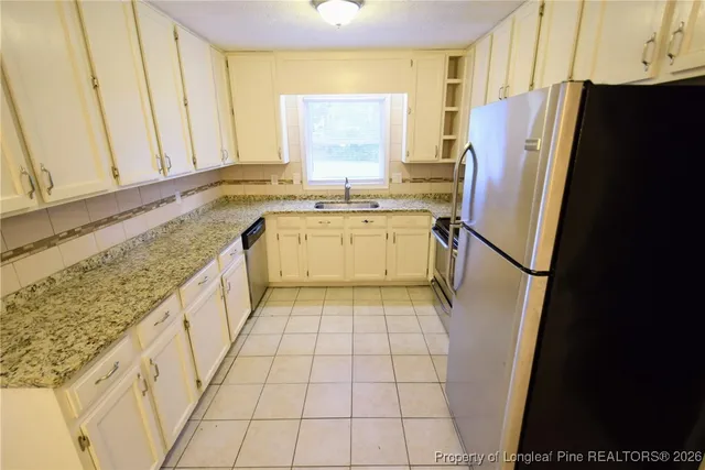 a bathroom with a granite countertop shower a sink and a stove
