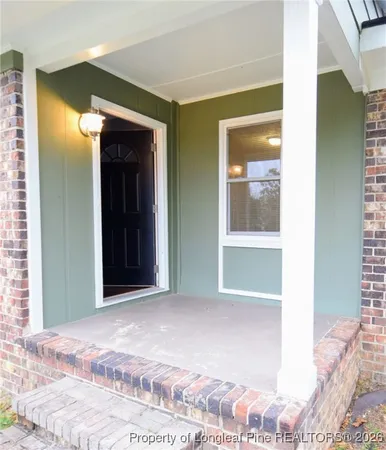 a view of a hallway with wooden floor and a bedroom