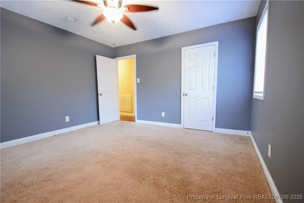 an empty room with a ceiling fan and a window